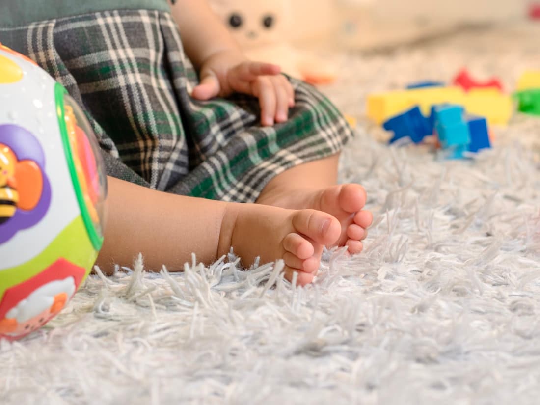 Tout-petit en éveil moteur sur un tapis de jeu
