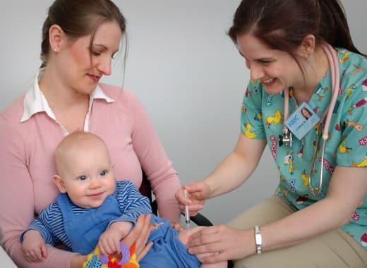 Infirmière puéricultrice auscultant un bébé